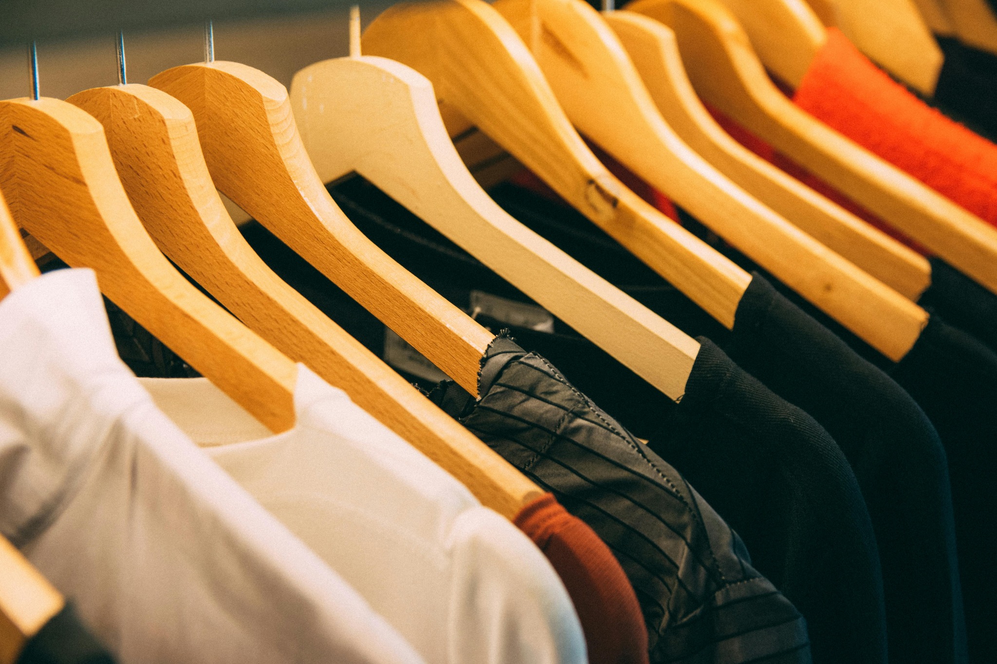 Close‑up of wooden hangers with garments